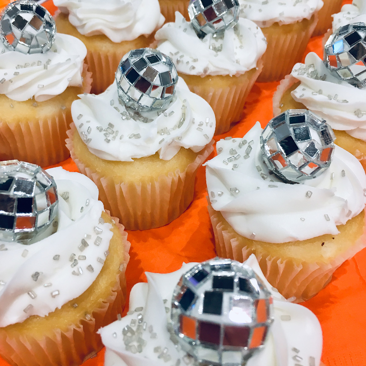 Festive cupcakes with mini disco ball decorations.