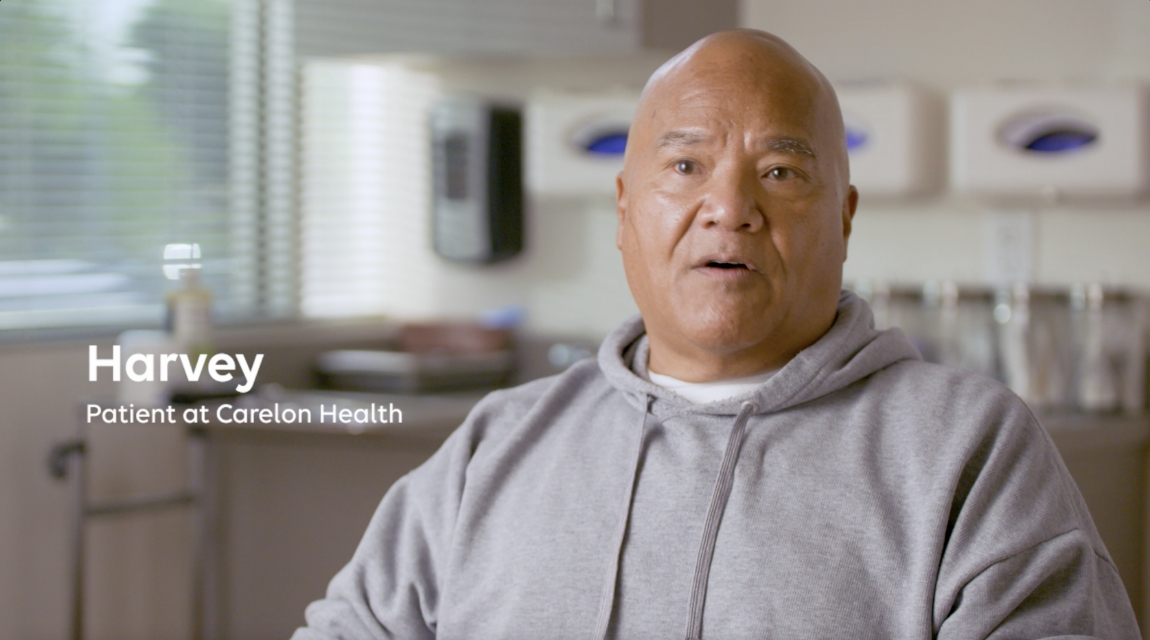 Harvey, a Carelon Health patient, seated in a clinic speaking during an interview.