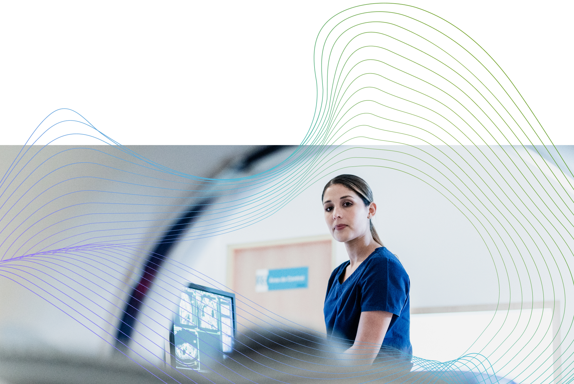 Healthcare professional reviewing medical scans on a computer in a clinical setting.