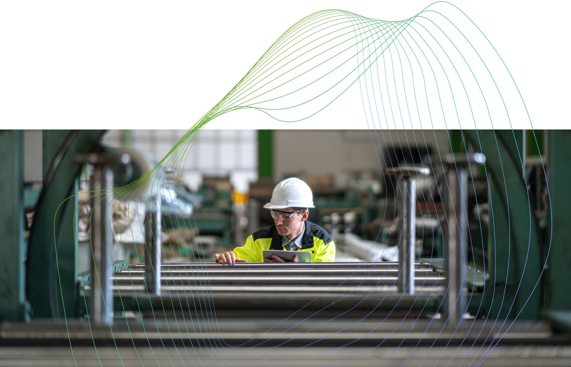 Engineer inspecting industrial machinery while using a tablet on factory floor.