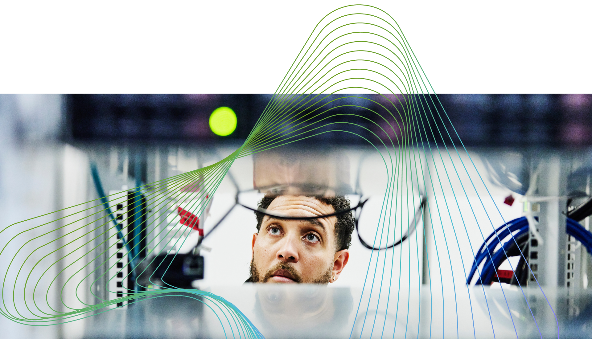 Technician inspecting network server hardware inside a data center rack.
